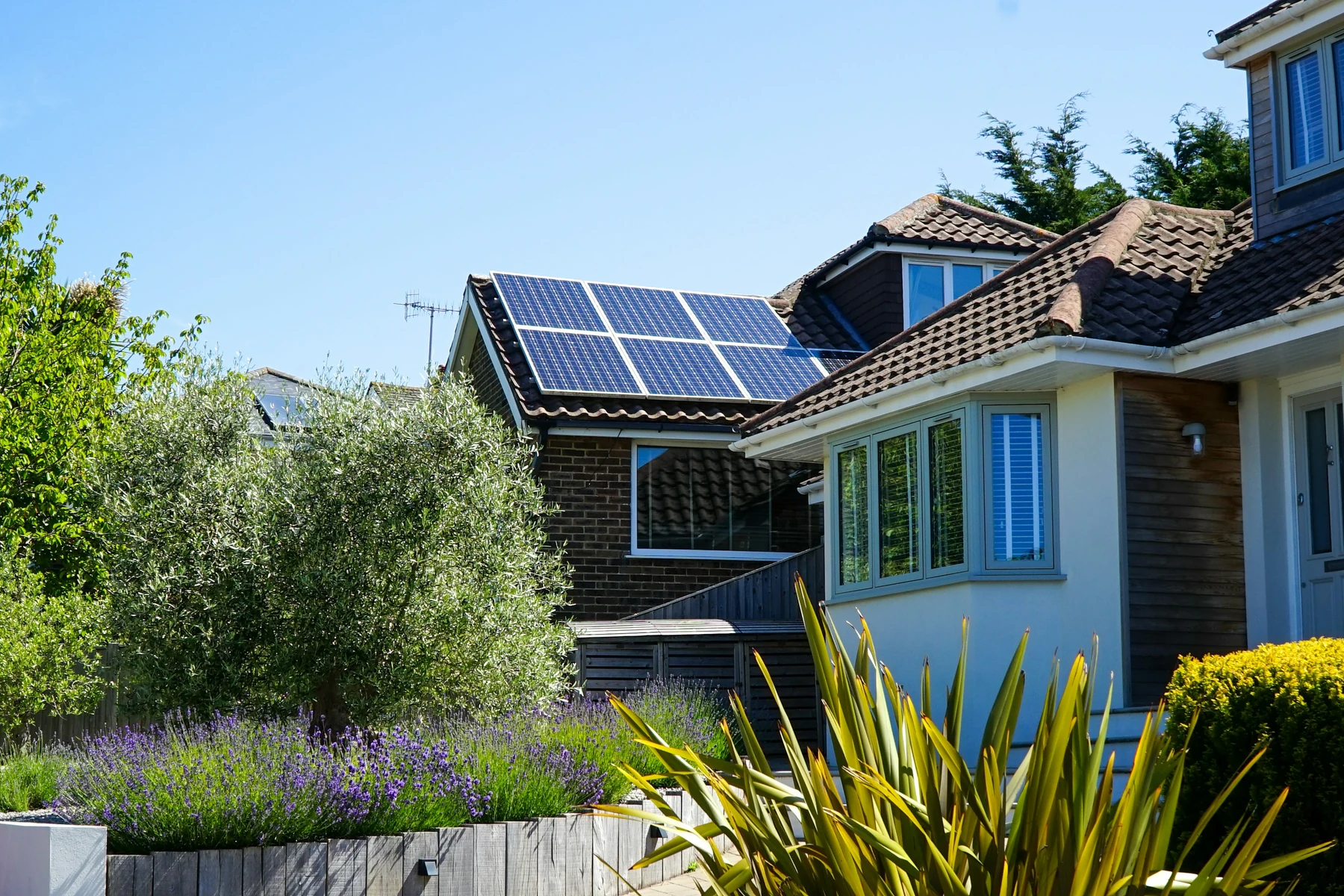 Toiture solaire résidentielle Maison individuelle entourée de verdure avec panneaux photovoltaïques sur le toit